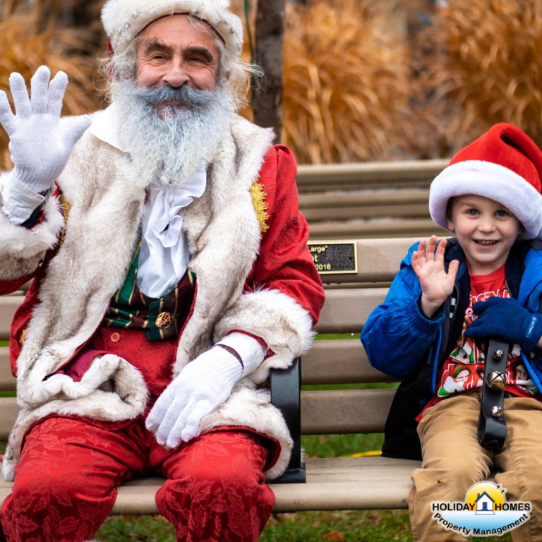Santa Claus sits on a park bench in Mariner's Park, Port Colborne, beside a smiling child. Both Santa and the child radiate joy and happiness, adding to the festive atmosphere. Credit: Holiday Homes Property Management.